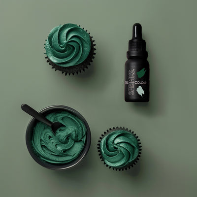Green cupcakes with a container of green frosting and a bottle labeled 'Sprinkles Colour' on a green background.