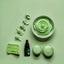 Green icing products including a cream, cake, and bottle on a green background