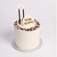 black and white candles on a cake with happy birthday plaque
