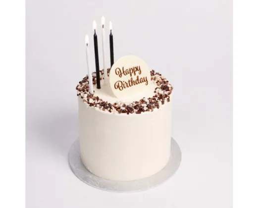 black and white candles on a cake with happy birthday plaque