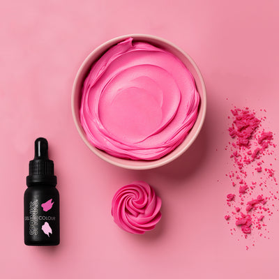 Pink food colouring by Sprinks with a dropper bottle on a pink background and icing examples