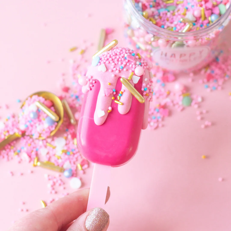 Pink ice cream bar with colorful sprinkles on a pink background