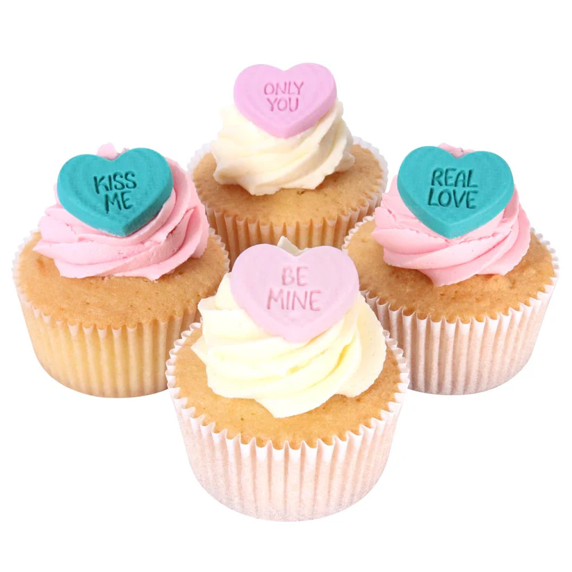 Cupcakes with conversation heart toppers on a white background