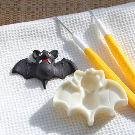 Jem bat cutter mould alongside a fondant example with modelling tools on a white mat