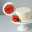 White cake with a red rose decoration on a gray background