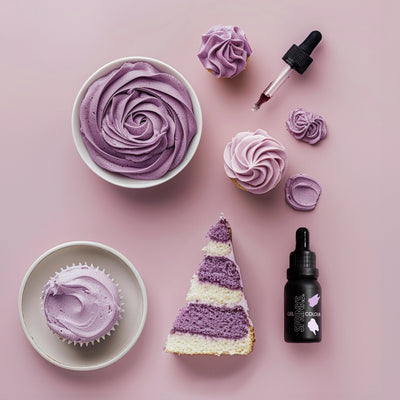 Purple-themed dessert items including cupcakes, a cake slice, and a Sprinks gel paste food colour bottle on a pink background.