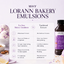 A promotional graphic for LorAnn Bakery Emulsions showing a bottle of lavender-colored emulsion on the right and a comparison chart on the left explaining differences between LorAnn Bakery Emulsions and Traditional Extracts. The background is a soft lavender, with decorative baked goods and nuts around the edges.