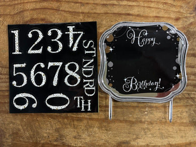 Black birthday cake topper with sparkly silver numbers and 'Happy Birthday!'