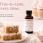 A bottle of Lorain's Super Strength Marshmallow Flavoring tands on a pink surface beside decorated cake pieces and marshmallows. Large text reads, 'True-to-taste, every time.