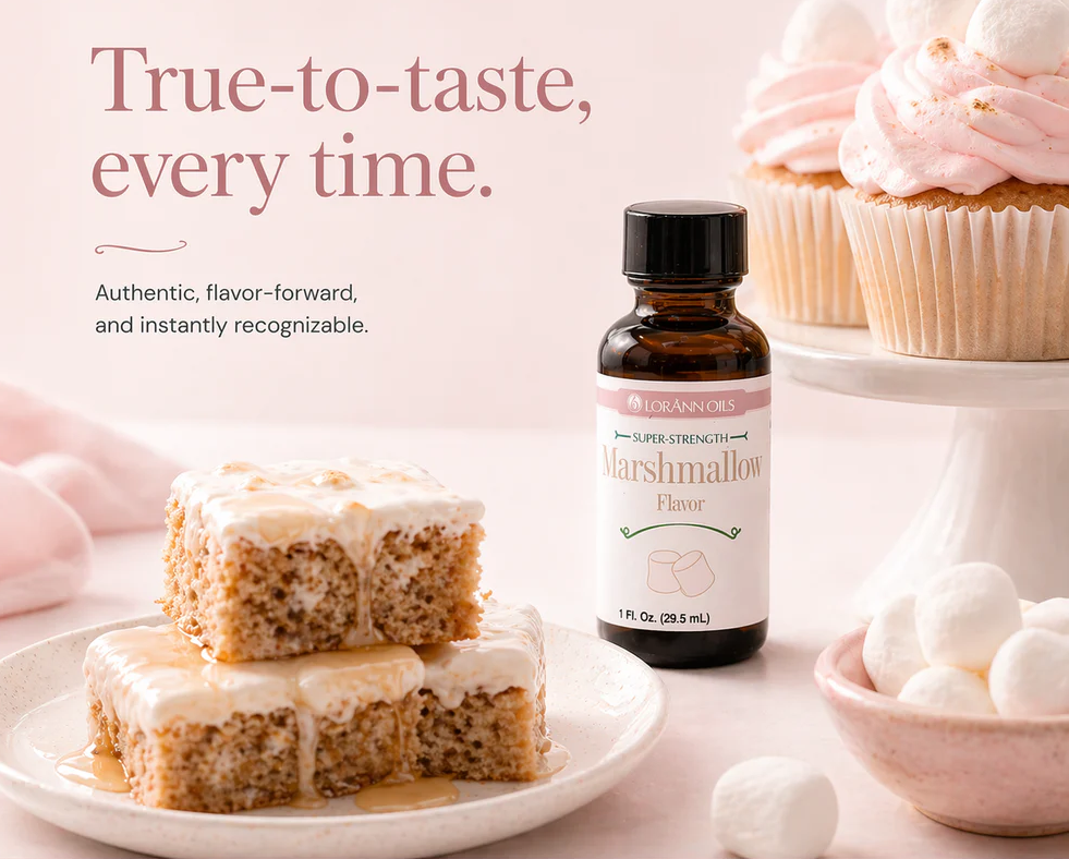 A bottle of Lorain's Super Strength Marshmallow Flavoring tands on a pink surface beside decorated cake pieces and marshmallows. Large text reads, 'True-to-taste, every time.