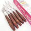 Set of palette knives with brown handles and metal blades, displayed in front of a pink packaging box.