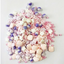 Pastel-colored candy mix with pearls, shells and star-shaped sprinkles on a white background