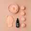 Black dropper bottle with pink cream and macarons on a beige background