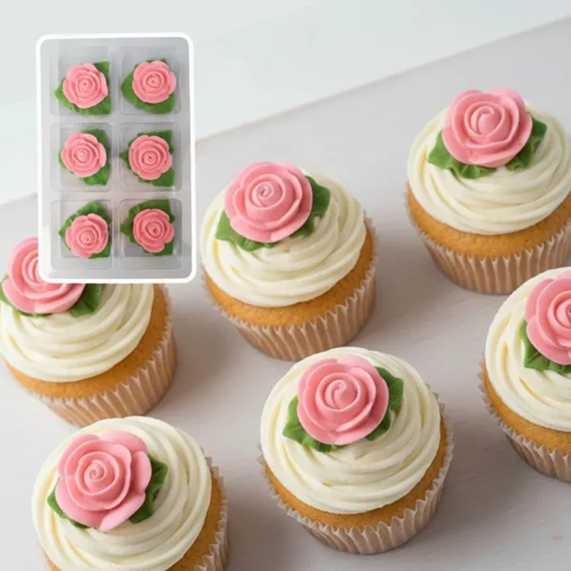 Cupcakes decorated with edible pink roses on a white buttercream swirl