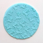 A round light blue fondant plaque with an embossed pattern of leaping deer and small dots, shown on a plain light background.