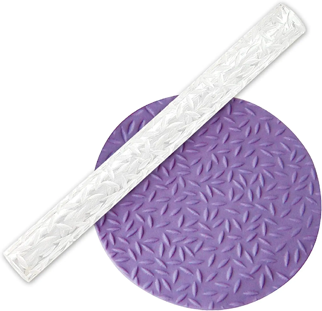 A clear textured roller with a diamond plate pattern, laid diagonally over a purple circular fondant sample showing the embossed texture.