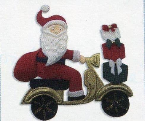 fondant icing decoration of Santa Claus on a scooter with a gift bag.
