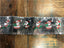 A silver cake frill with illustrated Santa Claus designs repeated along its length.