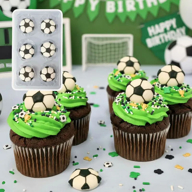 Cupcakes decorated with green frosting and soccer ball decorations on a table with a 'Happy Birthday' banner in the background.