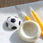 Soccer ball-shaped mold and tools on a textured surface with icing example of a soccer ball