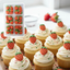 Cupcakes decorated with strawberry-shaped icing decorations.
