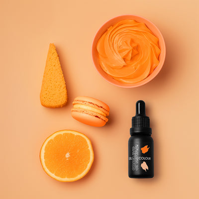 Orange-themed items including a bottle, cup, and fruit on an orange background