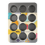 A Wilton 12-cup muffin pan in dark gray, shown in its original retail packaging with a colorful printed insert card. The Wilton brand name is clearly visible on the packaging.