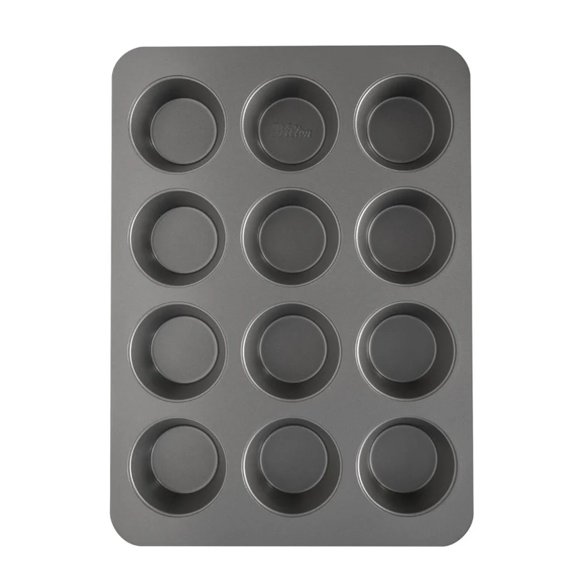 A dark gray non-stick 12-cup muffin tin with a rectangular shape and rounded corners, shown from a top-down perspective on a solid white background.
