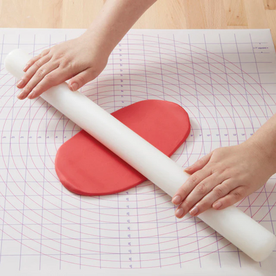Wilton wide rolling pin and a piece of fondant icing being rolled out on a pastry mat