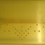 A gold-colored press ice tool with dotted patterns, likely used for creating decorative borders and patterns in cake icing.