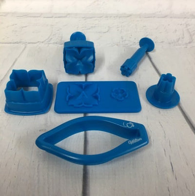 A set of blue plastic fondant/gumpaste hydrangea flower cutters and a silicone veining mat, branded by Wilton USA.