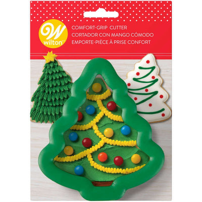 A Christmas tree-shaped cookie cutter with a comfort grip, packaged on a card showing the cutter decorated with colorful buttons and candy to suggest usage.