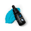 A bottle of SPRINKS Blue Gel Colour with a dropper, placed on a surface with blue food coloring spread around.
