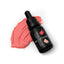 A black dropper bottle labeled 'SPRINKS Coral GEL COLOUR' with a few drops of coral-colored icing on a white surface.