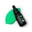 A bottle of SPRINKS Grass Green Gel Colour with a dropper, placed on a surface with green food coloring.