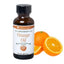 A bottle of LORANN OILS Orange natural flavoring oil next to a sliced orange.