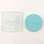 A clear debosser tool with the word 'Congrats!' imprinted on it, shown next to its matching blue-colored fondant icing example