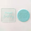 A happy birthday debosser tool. Alongside a fondant plaque in blue featuring the happy birthday design