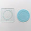 Clear acrylic debosser with circle of leaves frame. Along with a finished blue fondant plaque, showing example of use